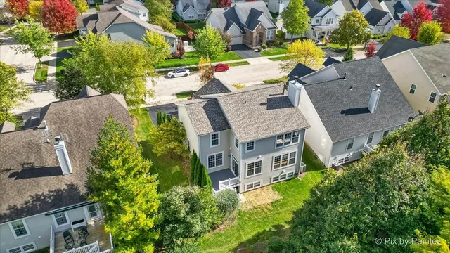 an aerial view of a house with a yard and large trees