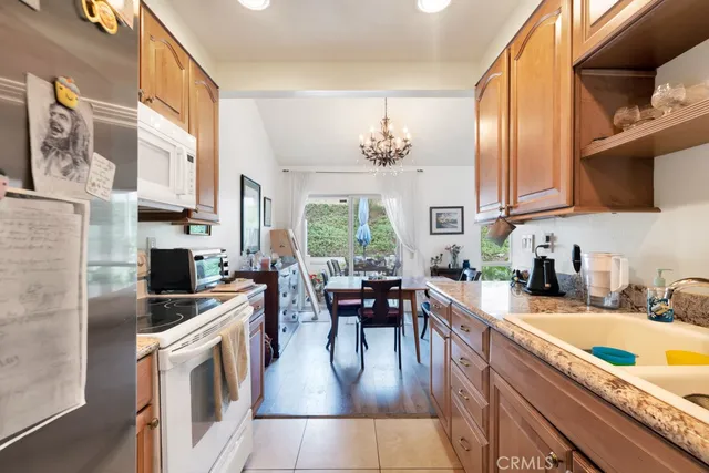 a kitchen with stainless steel appliances a stove a sink a oven a dining table and chairs