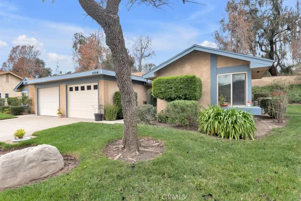 a view of a house with a yard and tree s