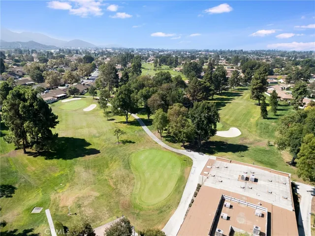 an aerial view of residential houses with outdoor space and trees