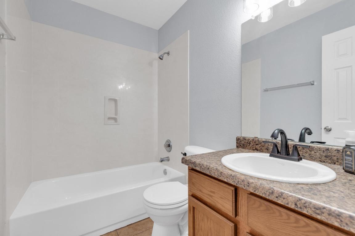 9301 Bellgrove Court Killeen, TX 76542 - Photo 17 of 22 a bathroom with a granite countertop sink toilet and shower