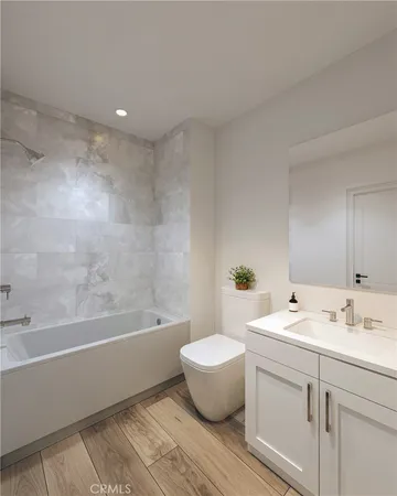 a bathroom with a bathtub a sink a toilet and a mirror