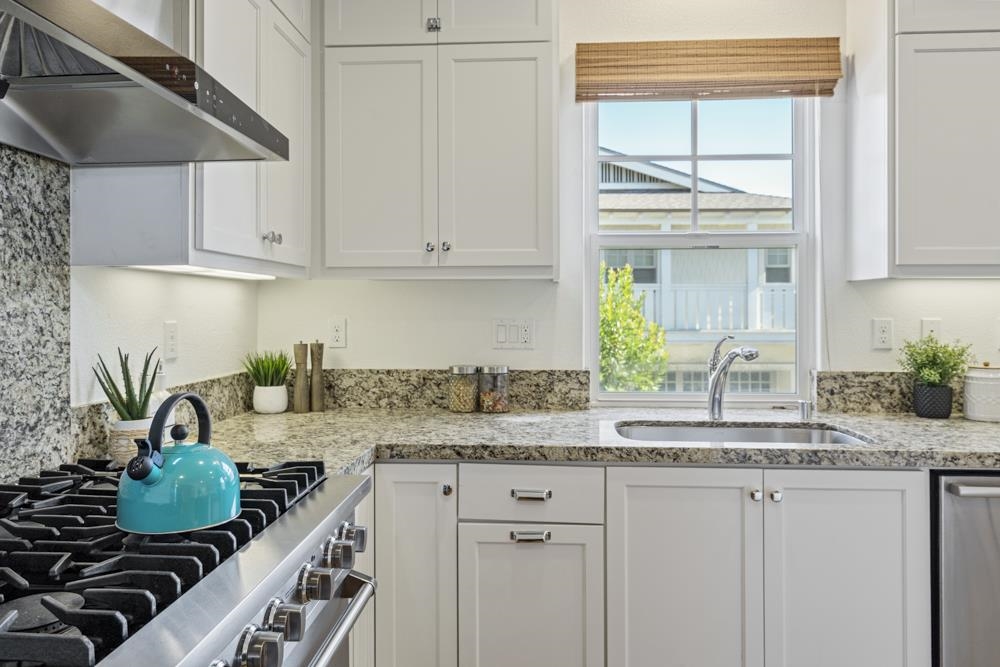 47236 Cavanaugh Common Fremont, CA 94539 - Photo 14 of 52 a kitchen with stainless steel appliances granite countertop a stove a sink and a white cabinets
