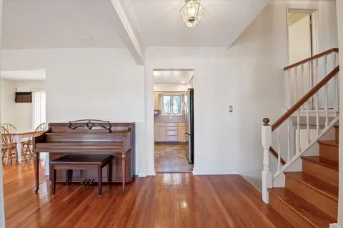 a living room with wooden floors and a piano