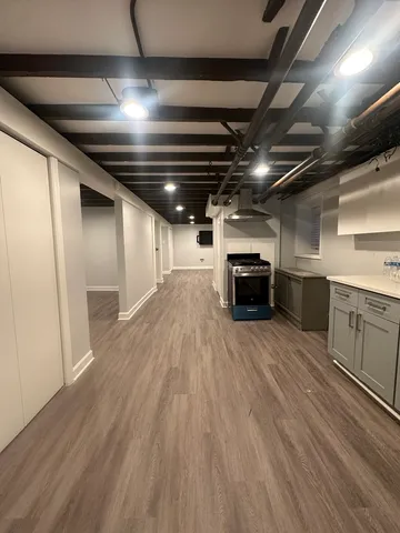 a big room with wooden floors and kitchen view