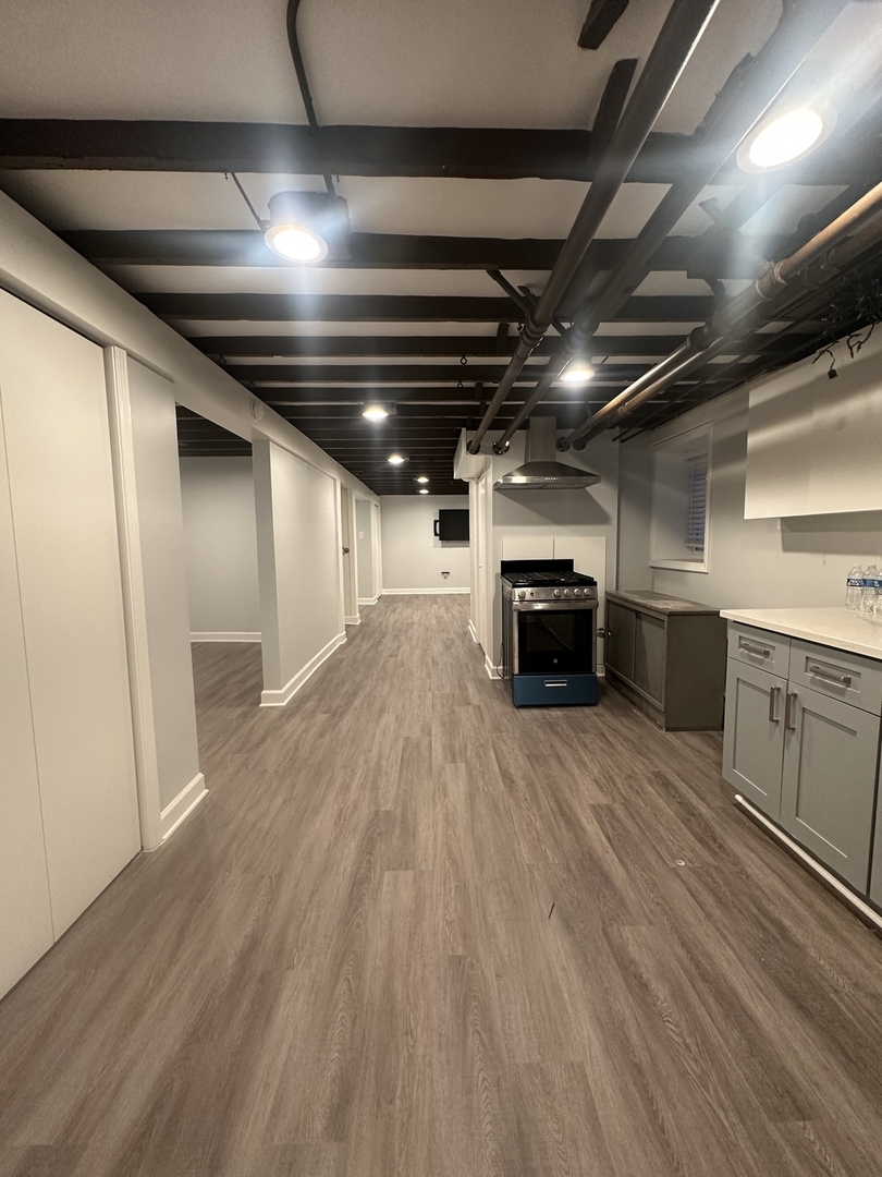 3016 South Throop Street, Unit GARDEN Chicago, IL 60608 - Photo 6 of 13 a big room with wooden floors and kitchen view