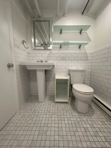 a bathroom with a sink a toilet and a mirror