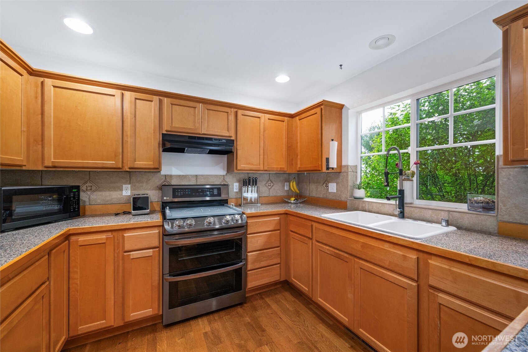 1877 Emerald Way Lynden, WA 98264 - Photo 17 of 38 a kitchen with granite countertop a stove a sink and a microwave