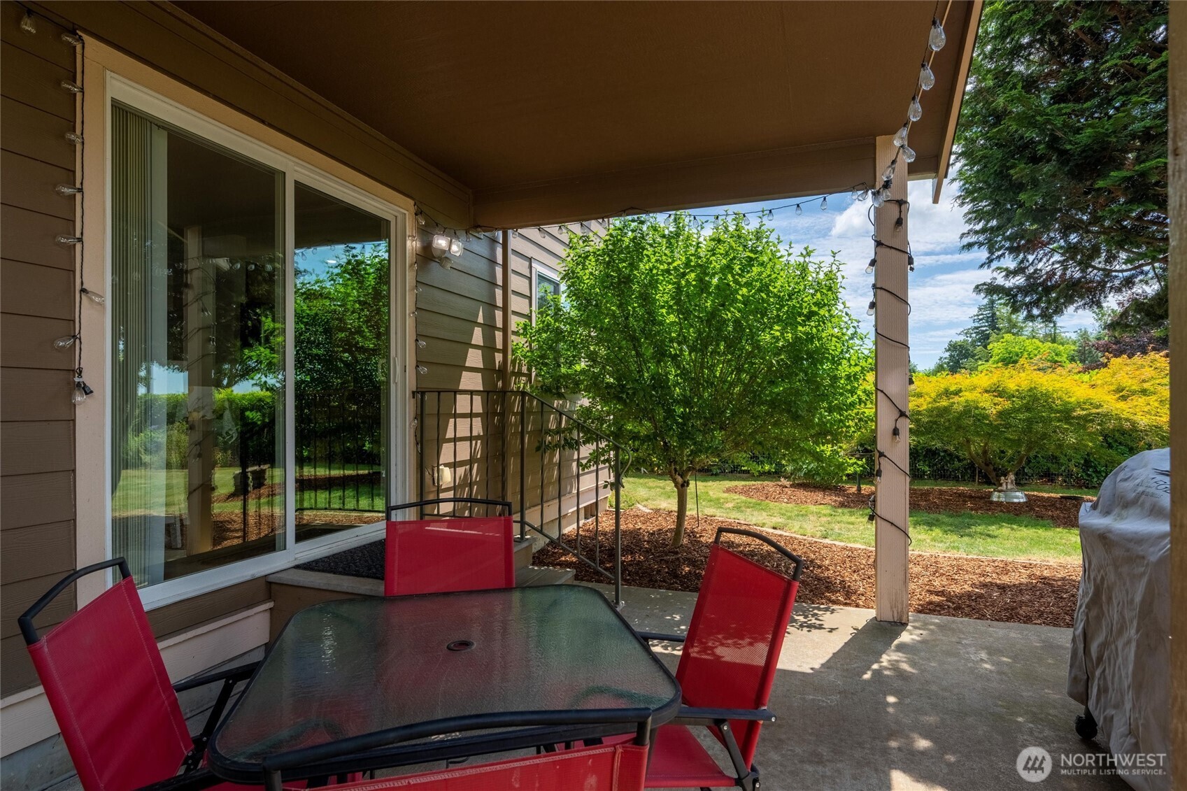 1877 Emerald Way Lynden, WA 98264 - Photo 28 of 38 a view of a patio with a table chairs and a backyard