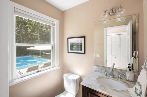 a bathroom with a granite countertop sink toilet and a mirror