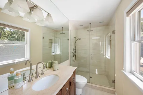 a bathroom with a sink a toilet and shower