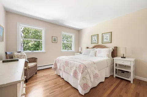 a bedroom with a bed and a desk next to a window