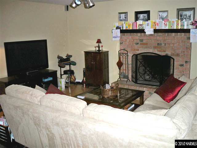 550 Nancy Circle, Unit 1 Reno, NV 89503 - Photo 4 of 10 a living room with furniture a flat screen tv and a fireplace