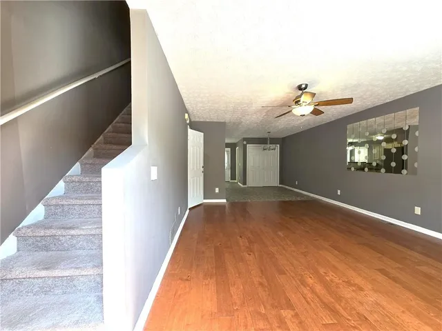 a view of a livingroom with wooden floor and stairs