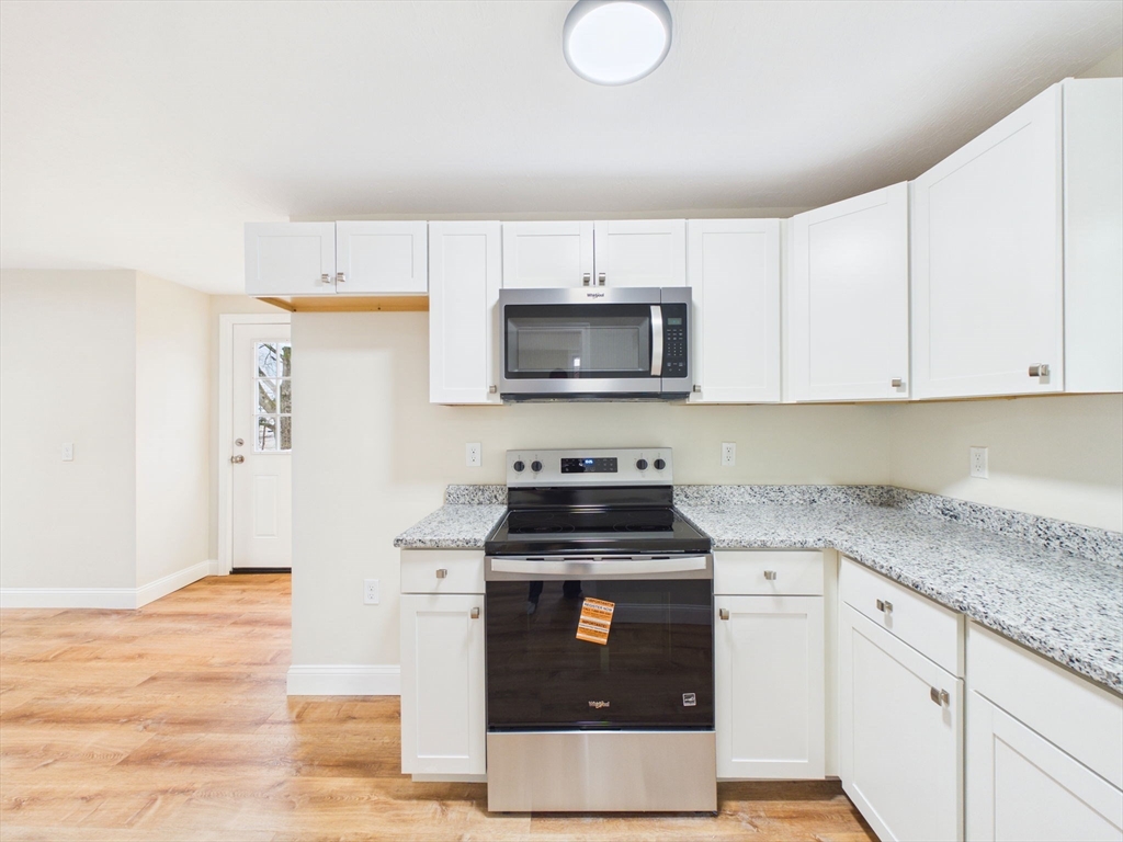 24 Middle Street Fairhaven, MA 02719 - Photo 28 of 38 a kitchen with granite countertop a stove top oven microwave and cabinets