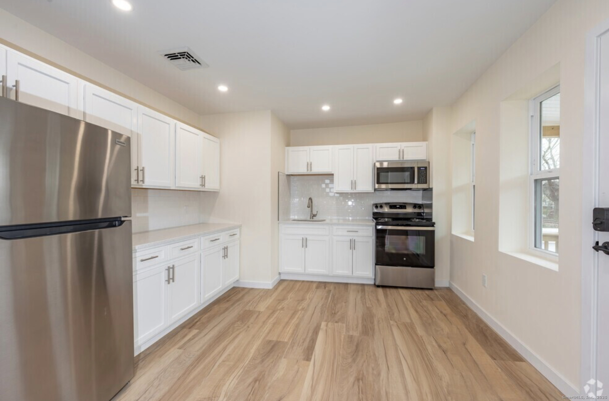 141 Bridge Street, Unit C Middletown, CT 06457 - Photo 2 of 12 a kitchen with a refrigerator a stove top oven and white cabinets