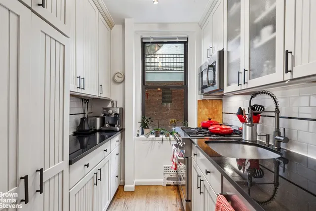 a kitchen with granite countertop a sink a stove and cabinets