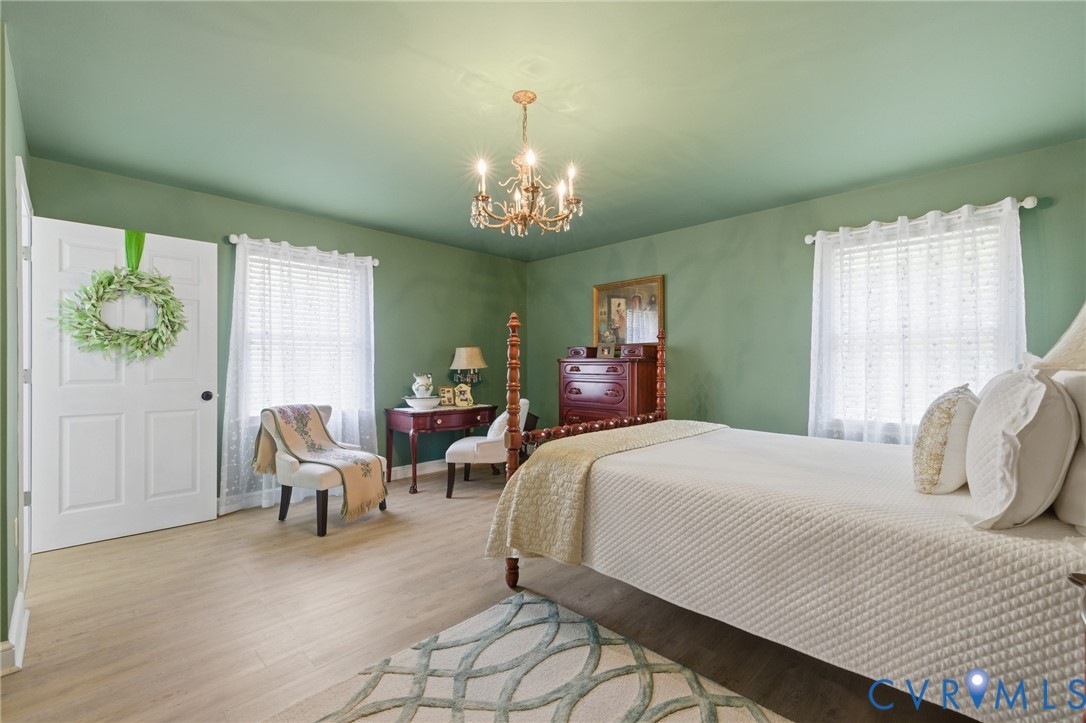 6606 West Quaker Road Disputanta, VA 23842 - Photo 24 of 32 Bedroom with LVP flooring, chandelier, en-suite ba