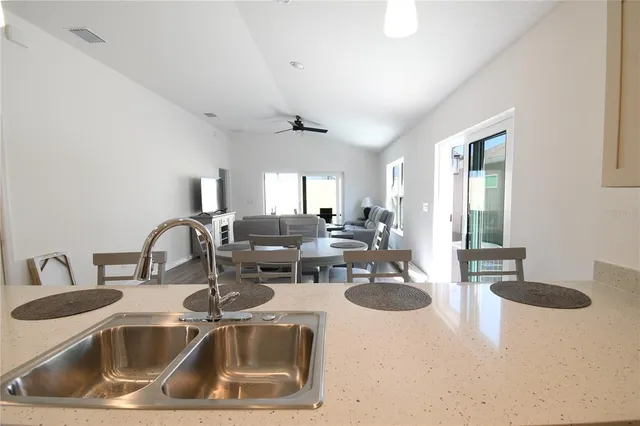 a kitchen with a sink a refrigerator and a stove top oven with wooden floor
