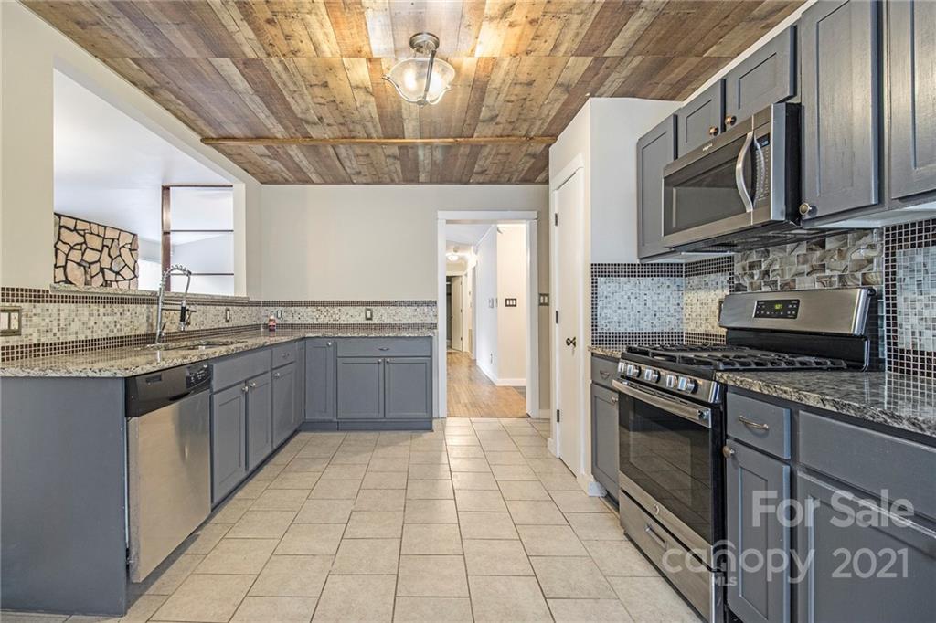 9618 Fairway Ridge Road Charlotte, NC 28277 - Photo 4 of 20 a kitchen with stainless steel appliances granite countertop a stove a sink and a microwave