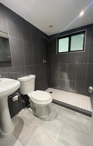 a bathroom with a toilet a sink and shower