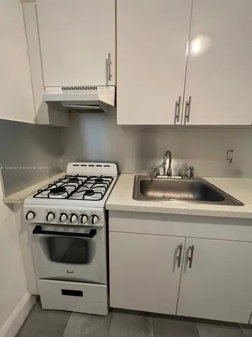 a white stove top oven sitting inside of a kitchen