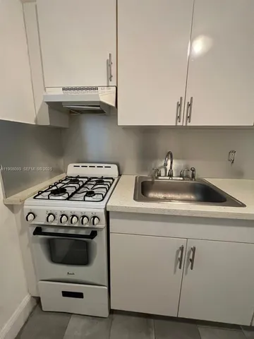 a white stove top oven sitting inside of a kitchen