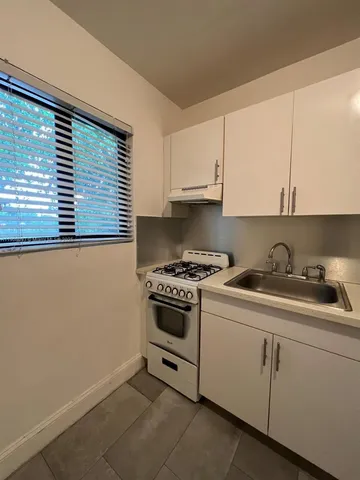 a kitchen with cabinets appliances a sink and a window