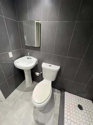 a bathroom with a toilet sink and mirror