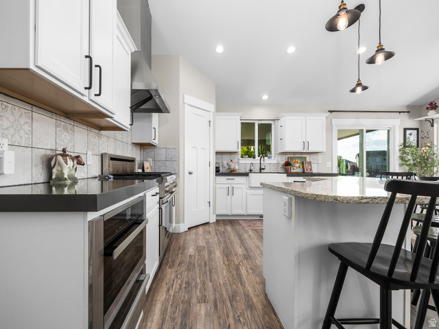 7 Sterling Loop Vineyard, UT 84059 - Photo 16 of 43 Bright kitchen featuring white cabinetry with dark hardware, a center island with a light-toned countertop, and wood-finish flooring