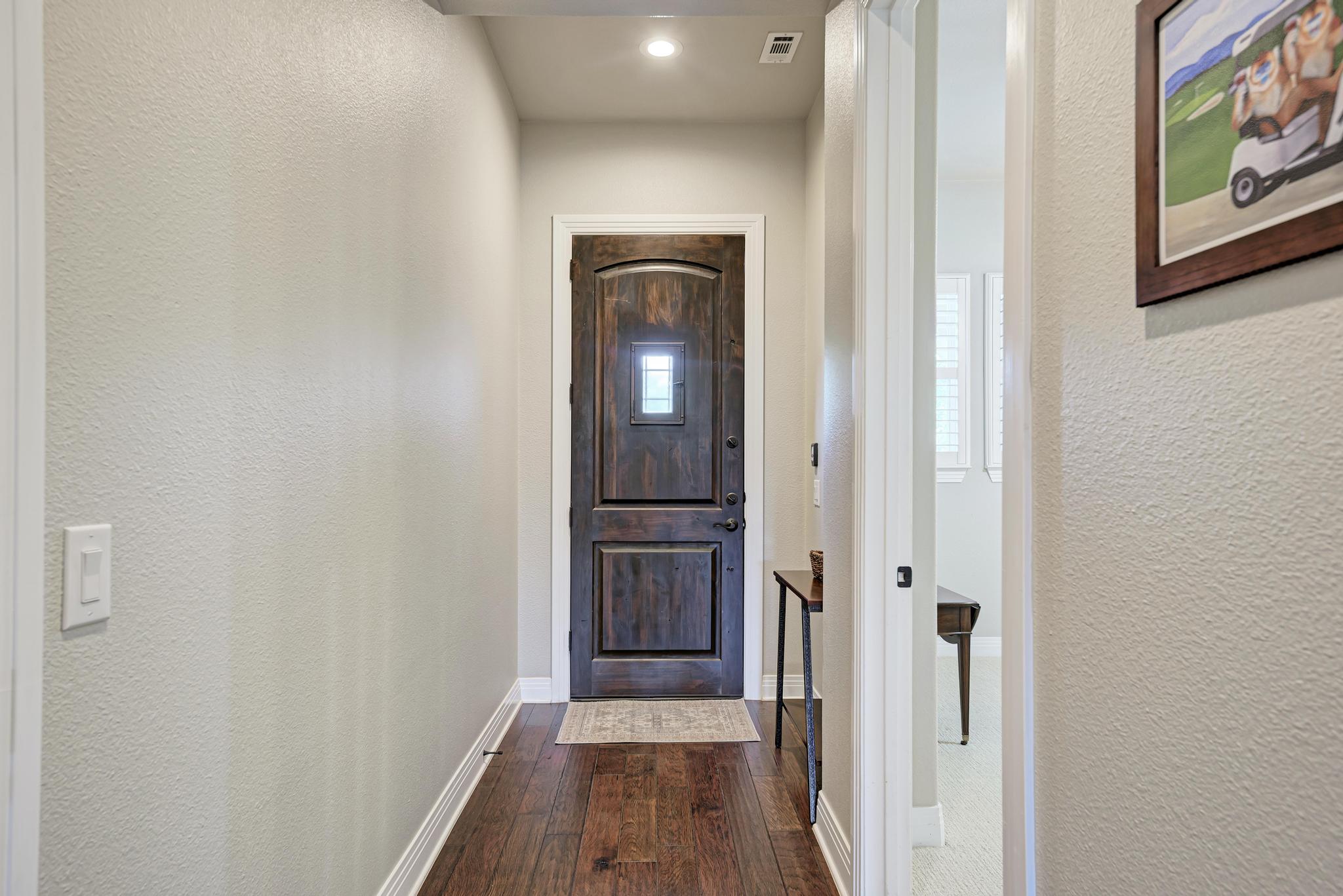 2601 North Quinlan Park Road, Unit 506 Austin, TX 78732 - Photo 6 of 39 Rich hardwood floors welcome you to a classic entryway, featuring a solid wood front door with a glass inlay.