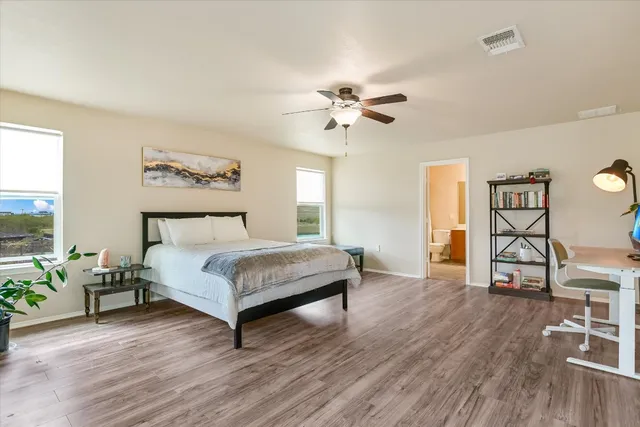 a bedroom with a bed chandelier and a window