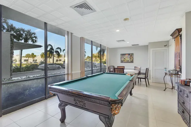 a room with pool table and windows