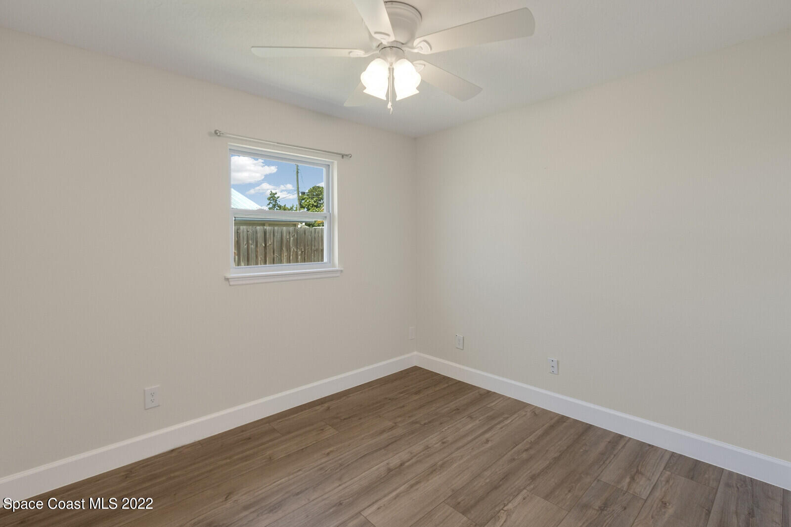 2834 Rheims Avenue Melbourne, FL 32935 - Photo 11 of 19 wooden floor in an empty room with a window