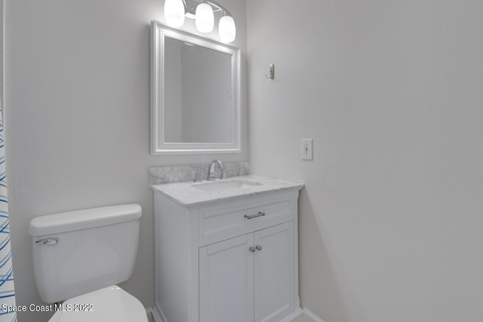 2834 Rheims Avenue Melbourne, FL 32935 - Photo 12 of 19 a bathroom with a toilet sink and mirror