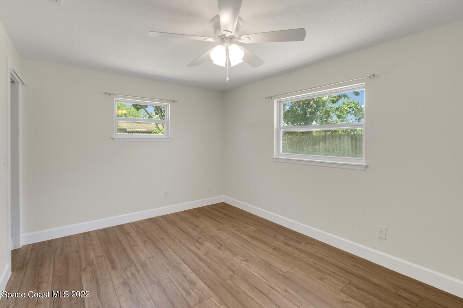 2834 Rheims Avenue Melbourne, FL 32935 - Photo 13 of 19 wooden floor in an empty room with a window
