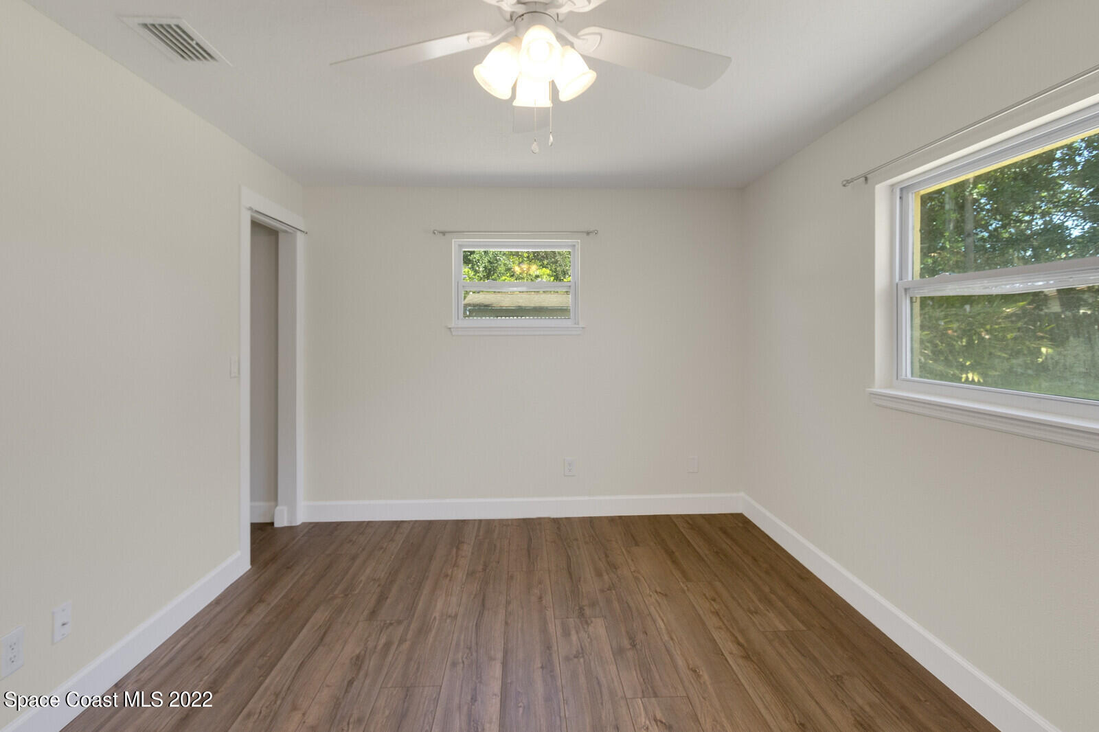 2834 Rheims Avenue Melbourne, FL 32935 - Photo 14 of 19 wooden floor in an empty room with a window