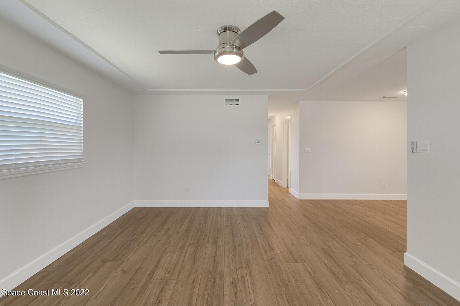 2834 Rheims Avenue Melbourne, FL 32935 - Photo 5 of 19 an empty room with wooden floor and a ceiling fan