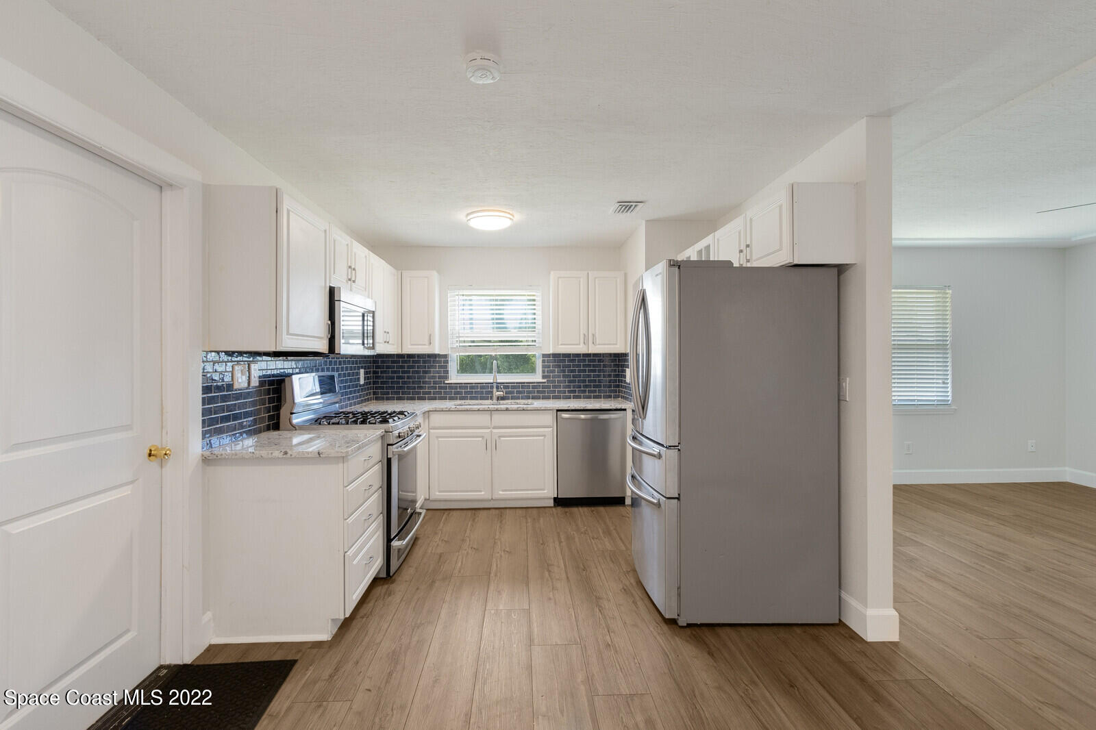 2834 Rheims Avenue Melbourne, FL 32935 - Photo 7 of 19 a kitchen with a refrigerator a sink and cabinets