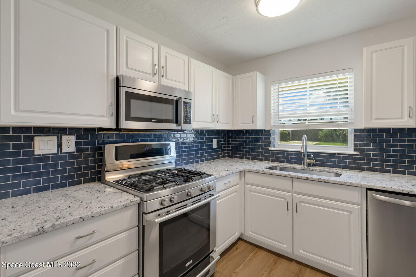 2834 Rheims Avenue Melbourne, FL 32935 - Photo 8 of 19 a kitchen with granite countertop cabinets stainless steel appliances a sink and window