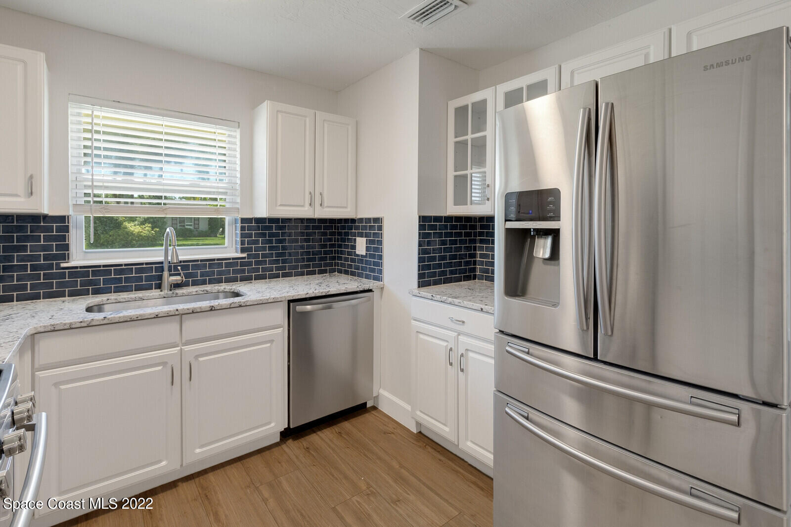 2834 Rheims Avenue Melbourne, FL 32935 - Photo 9 of 19 a kitchen with granite countertop white cabinets and refrigerator