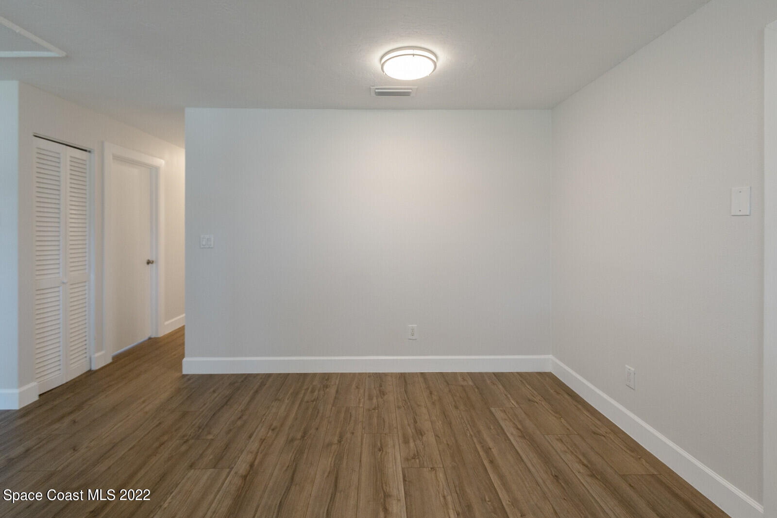 2834 Rheims Avenue Melbourne, FL 32935 - Photo 10 of 19 a view of an empty room with wooden floor and a window