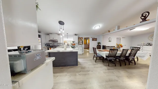 a kitchen with kitchen island a dining table and chairs