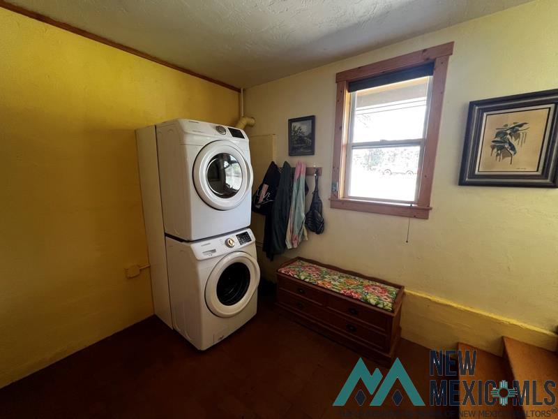 150 Forrest Service Road 124 Road Chamisal, NM 87521 - Photo 14 of 42 Laundry area featuring stacked washer / drying machine and a textured ceiling