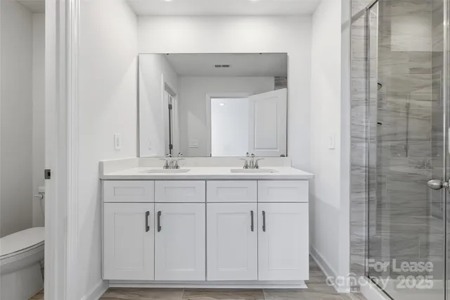 a bathroom with a shower sink and mirror