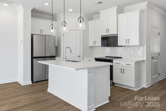 a kitchen with white cabinets and stainless steel appliances