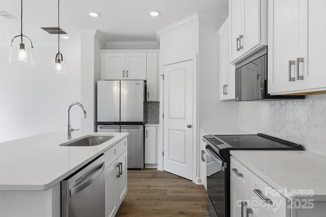 a kitchen with stainless steel appliances granite countertop a sink stove and refrigerator