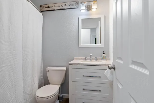 a bathroom with a toilet a sink and mirror