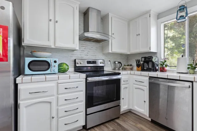 a kitchen with cabinets stainless steel appliances and a window