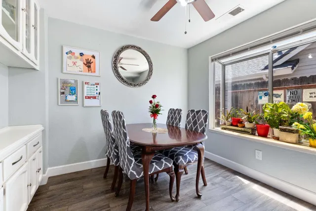 a view of a dining room with furniture and a chandelier fan